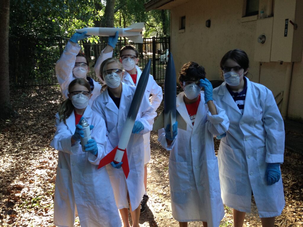 Students spray painting model rockets